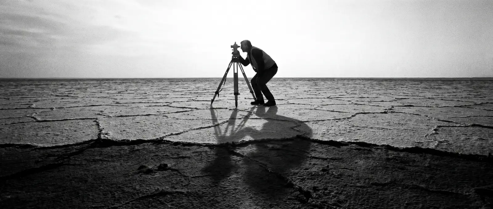 Surveyor measuring a vast salt flat with a theodolite, representing an AI search visibility audit