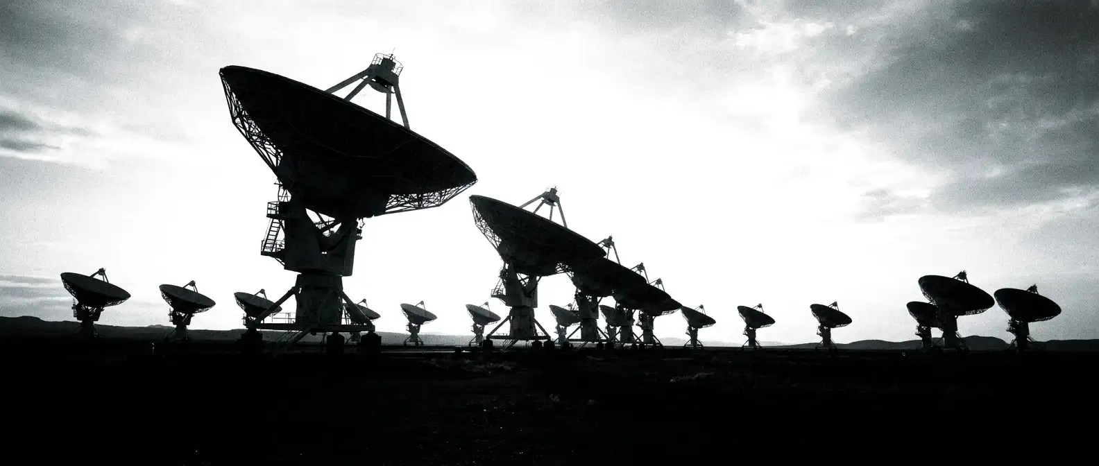 Field of radio telescope dishes aligned at dawn, representing continuous brand mention monitoring