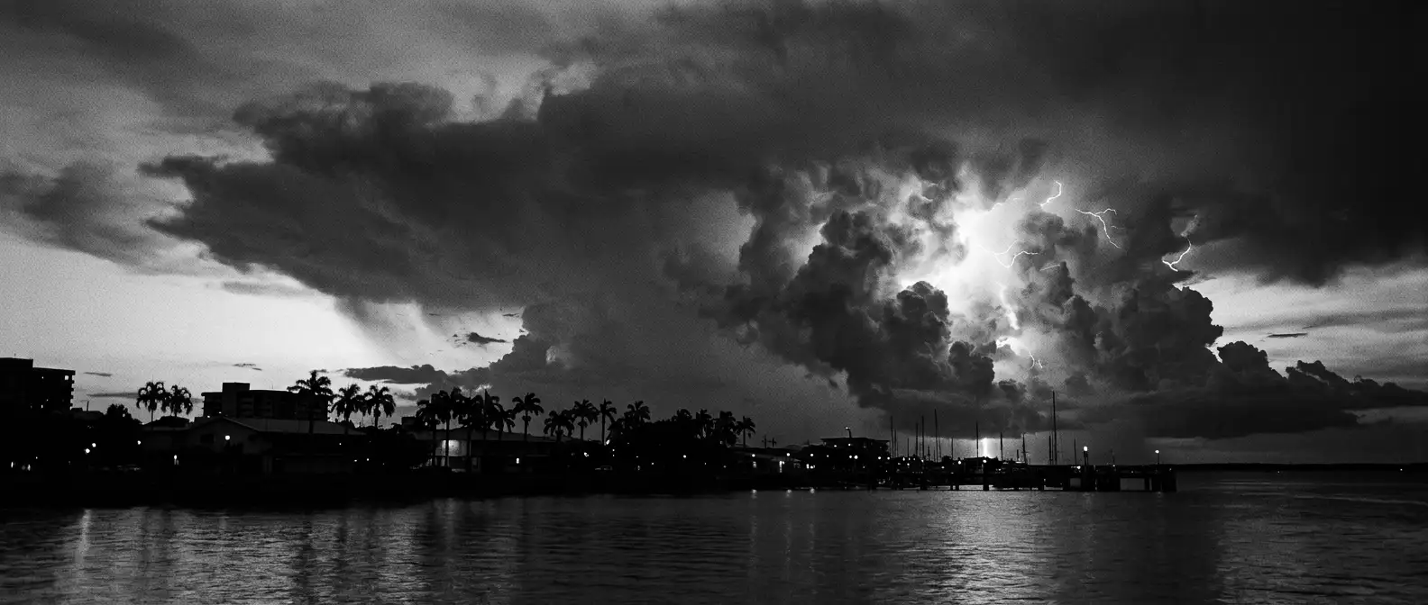 Darwin harbour at dusk under a towering monsoon thunderhead, representing AI search visibility for Darwin businesses
