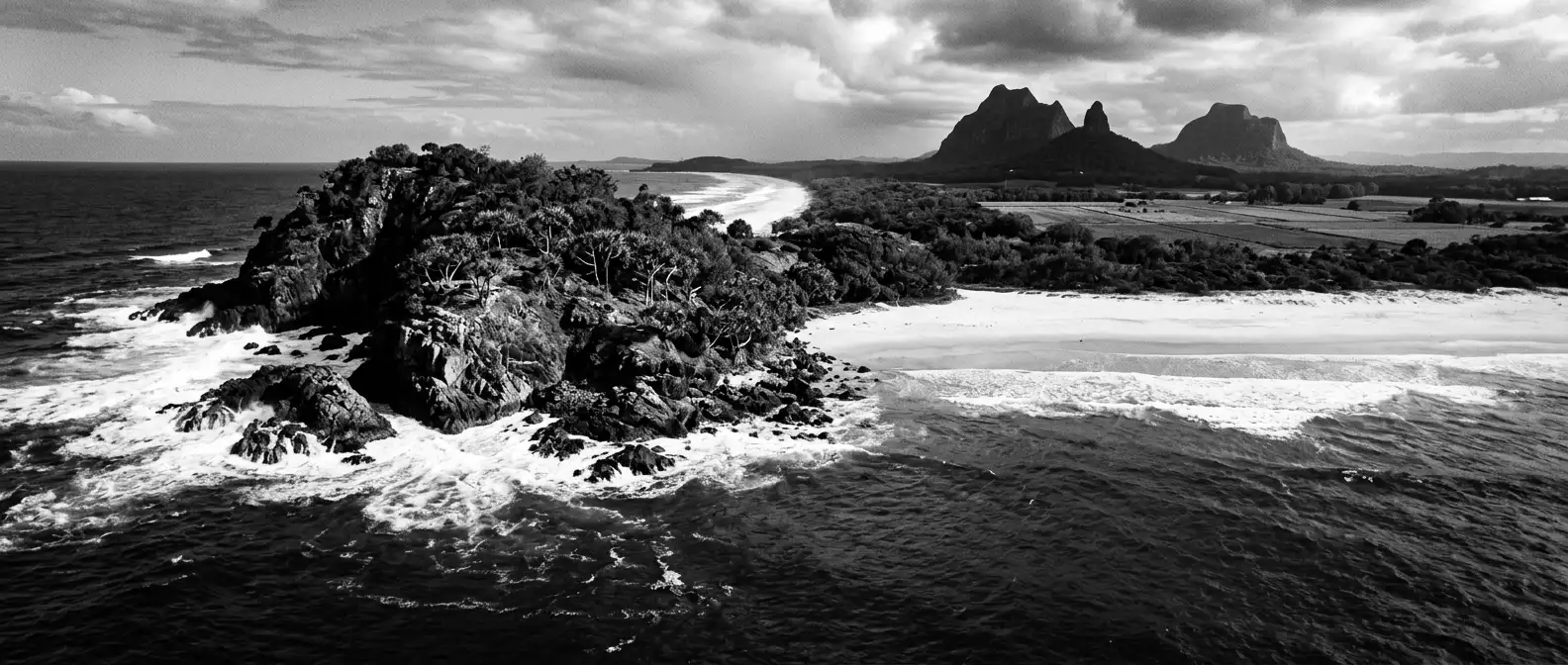 Aerial view of a Sunshine Coast headland and beach with volcanic peaks inland, representing AI search visibility for Sunshine Coast businesses